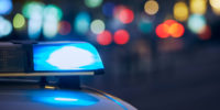 Blaues Blinklicht der Sirene des Polizeiautos in der nächtlichen Stadtstraße.