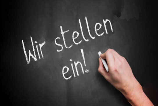 Schwarze Tafel mit weißer Kreideschrift " Wir stellen ein"