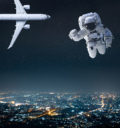 Night sky over a city with airplane and astronaut